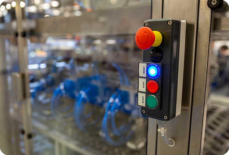 Control unit with Start, Stop, Reset buttons, system cabinet with glass door behind it, compressed air hoses